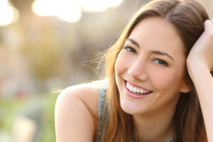 smiling young woman sitting outdoors on a pleasant day and finally understanding what is EMDR
