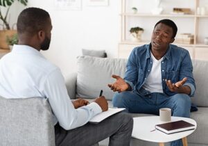 man talking to therapist in anger management treatment
