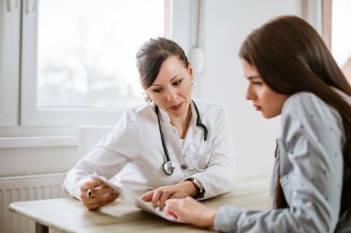 female medical professional explains medication management to female patient