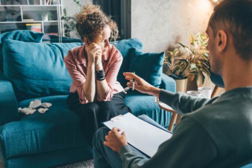 young woman looks away as she receives one-on-one counseling from a therapist