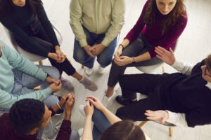 top down view of a group of adults in a circle while a therapist leads discussion
