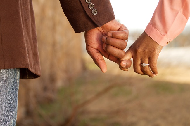 close up of a couple with hands joined and wedding rings visible