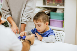male child performing a manual dexterity task for a therapist