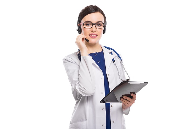 young female medical professional wearing transcription headset while holding clipboard