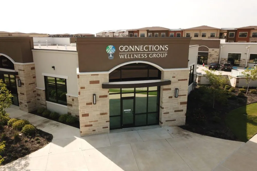 Exterior photograph of Connections Wellness Group building showing brick and stone facade with signage and green landscaping