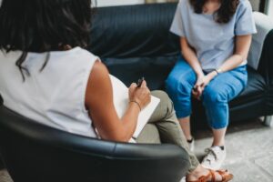 female therapist meeting with young woman to explain how to find mental health treatment in denton, texas