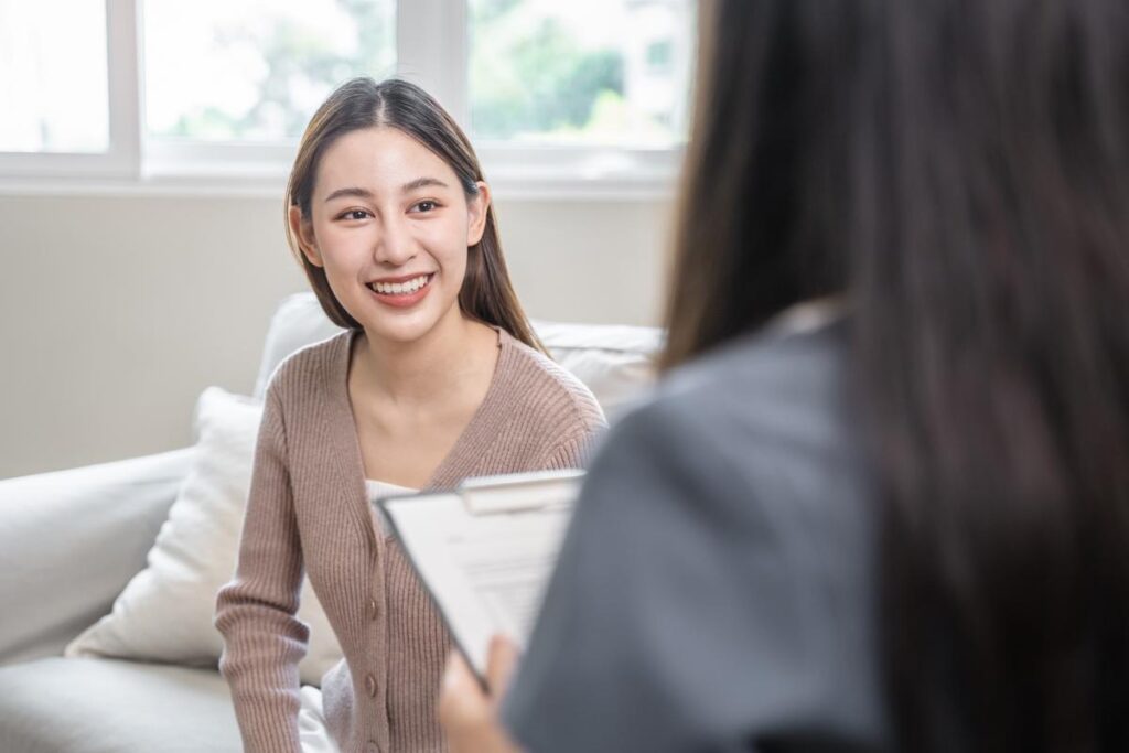 Young woman smiling and talking to her therapist about outpatient mental health treatment in prosper, texas