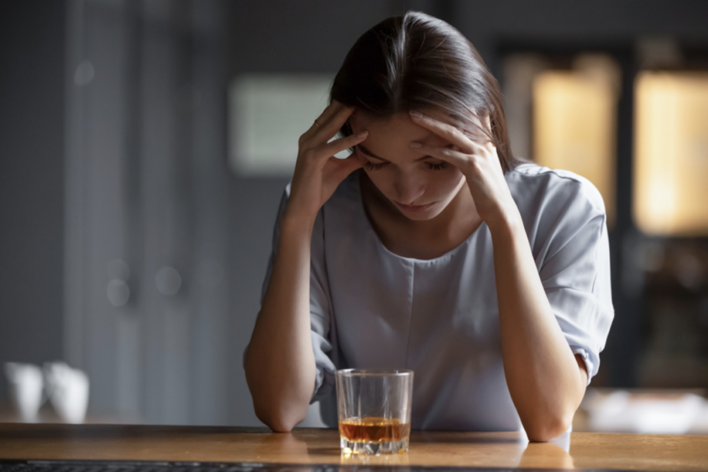 Women feeling anxious as she's looking at an alcoholic drink